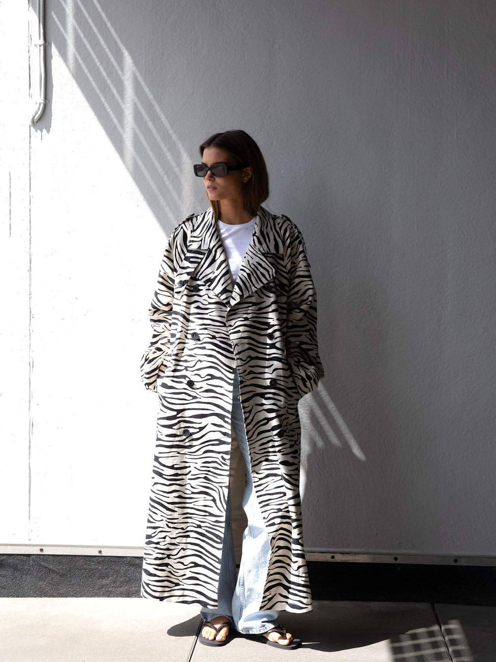 A model showcases a stylish zebra-striped coat, paired with a simple white tee and sunglasses, embodying MEOTINE's chic aesthetic.