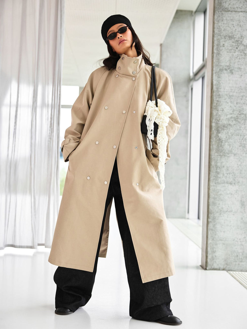 A model showcases a stylish beige trench coat with a belted waist, paired with wide-leg jeans, embodying MEOTINE's chic aesthetic.