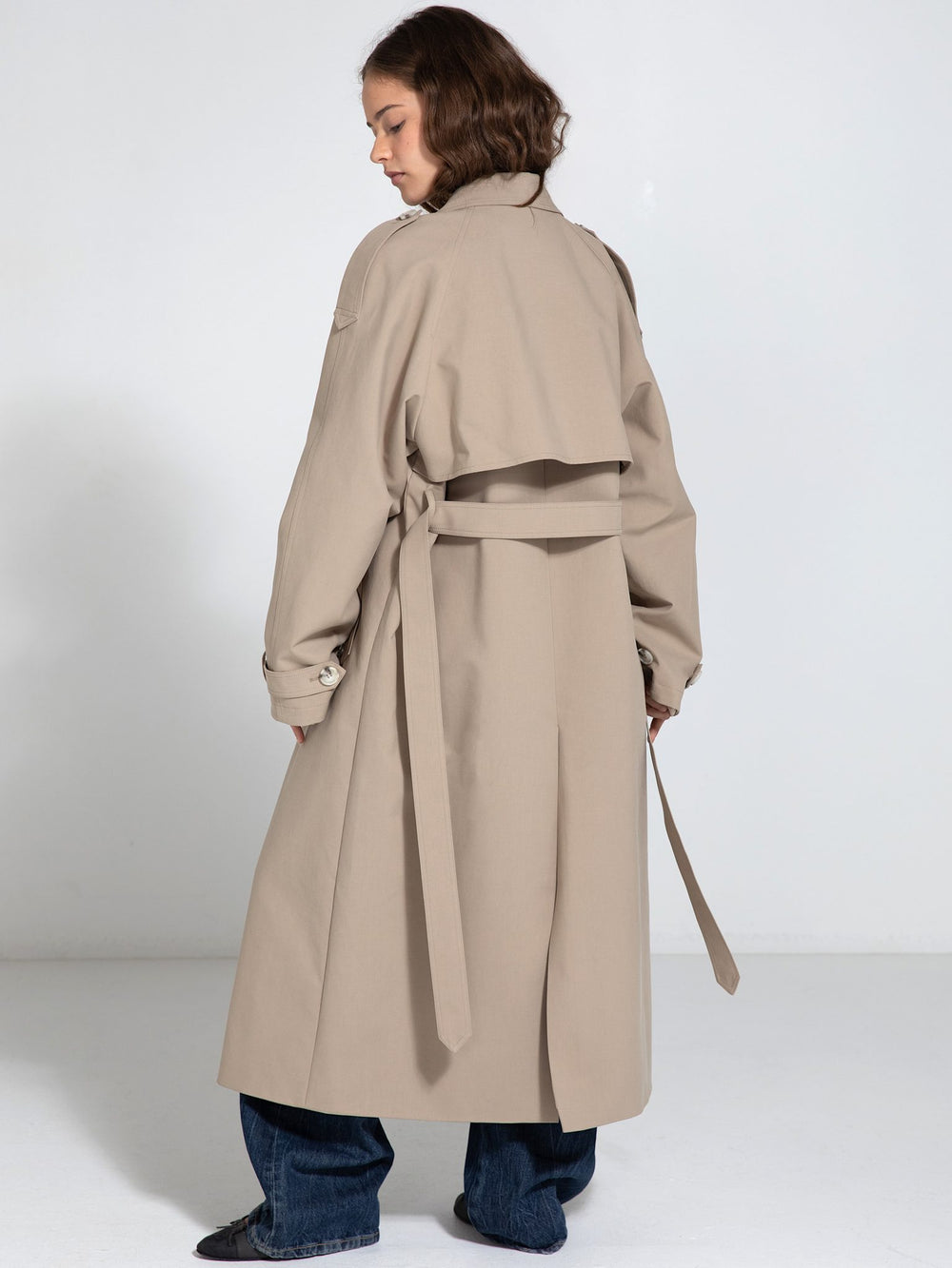 A model poses in a stylish beige trench coat with a relaxed fit, showcasing MEOTINE's contemporary design and elegance.
