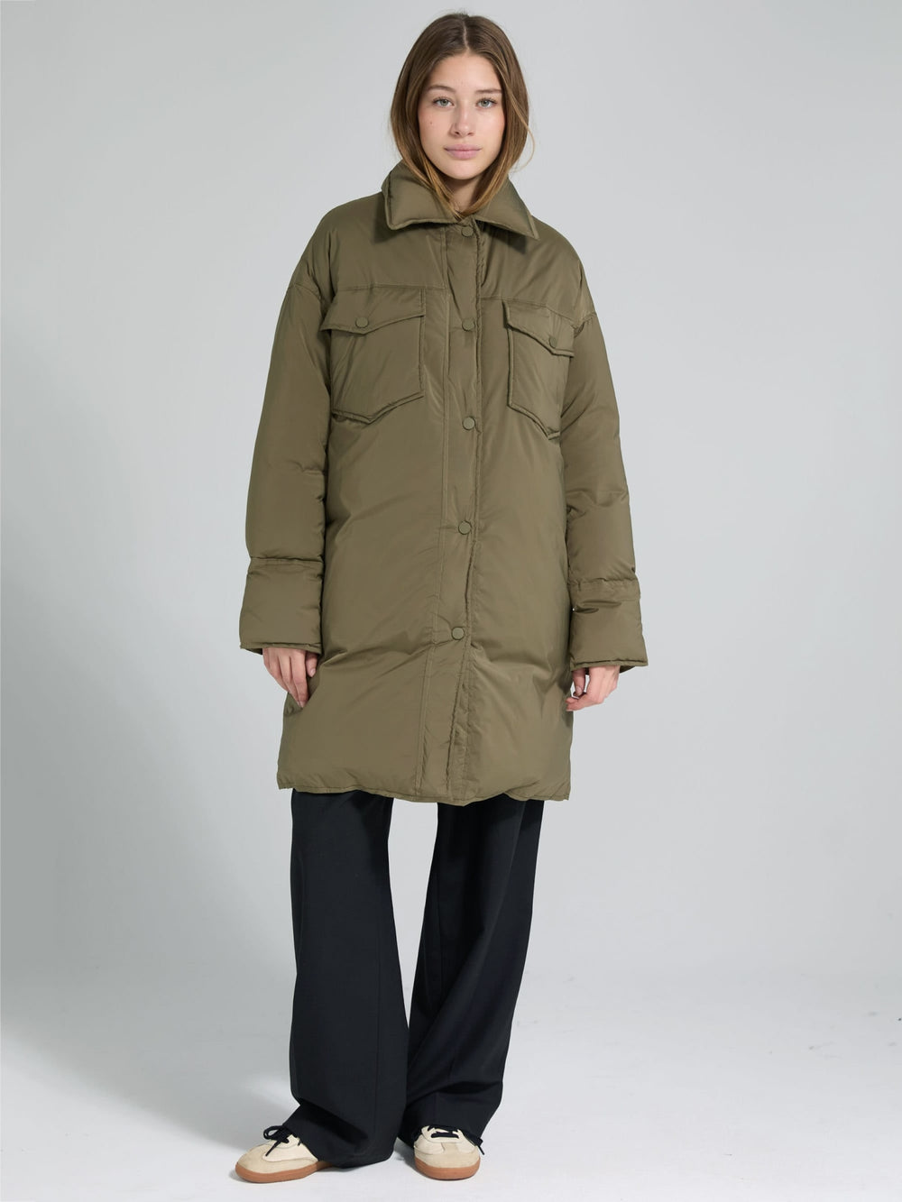 A model wears a stylish olive green oversized puffer coat with large pockets, showcasing MEOTINE's trendy winter fashion.