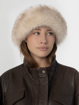 A model wearing a soft, fluffy beige hat paired with a dark brown leather jacket, showcasing MEOTINE's stylish winter accessory.