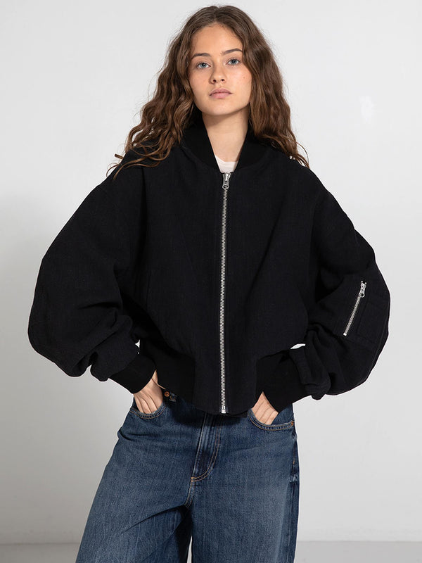 A model wears a stylish black cropped jacket with oversized sleeves, showcasing a modern look by MEOTINE.
