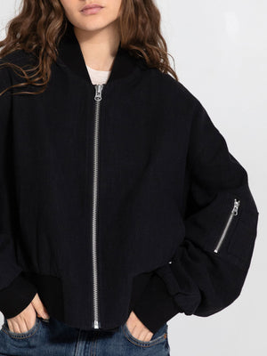 Casual black bomber jacket with a zip front and oversized sleeves, styled by MEOTINE for a relaxed, trendy look.