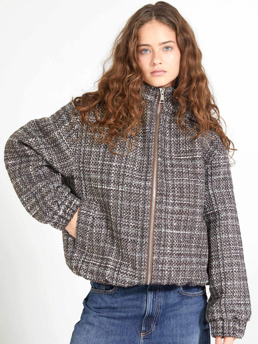 Stylish woman in a cozy, oversized plaid jacket with a hood, paired with denim jeans, showcasing MEOTINE's chic design.